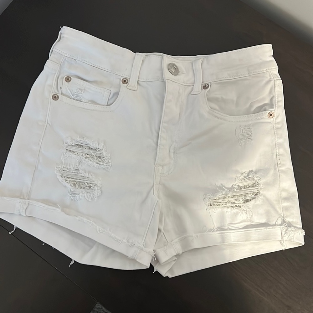 American eagle white denim distressed shorts with flower details on distressing.
